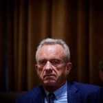 An image of HHS Secretary Robert F. Kennedy Jr., seated and wearing a blue suit at a Cabinet meeting.